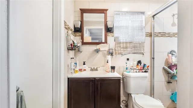 a bathroom with a sink vanity mirror and toilet