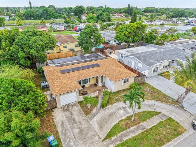 an aerial view of a house with a garden and lake view