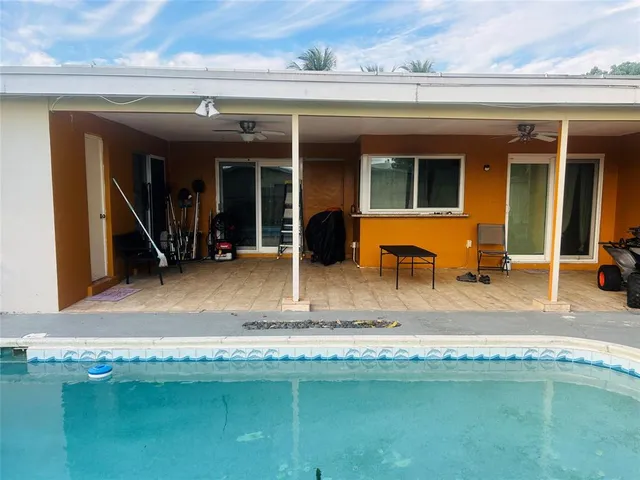a view of a house with swimming pool and sitting space