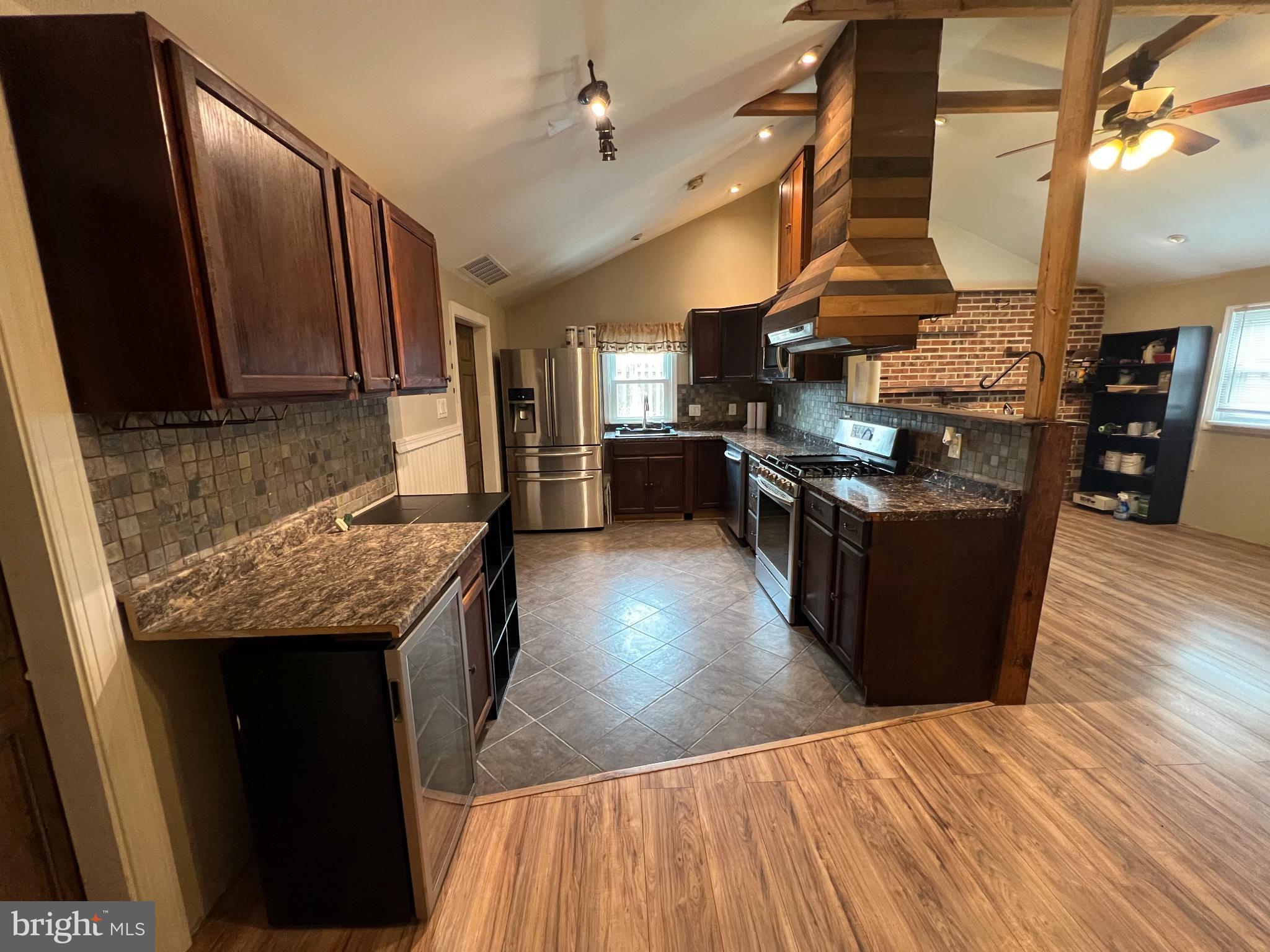 30 Duane Road Doylestown, PA 18901 - Photo 7 of 26 a kitchen with stainless steel appliances granite countertop a stove a refrigerator a sink dishwasher and wooden cabinets with wooden floor