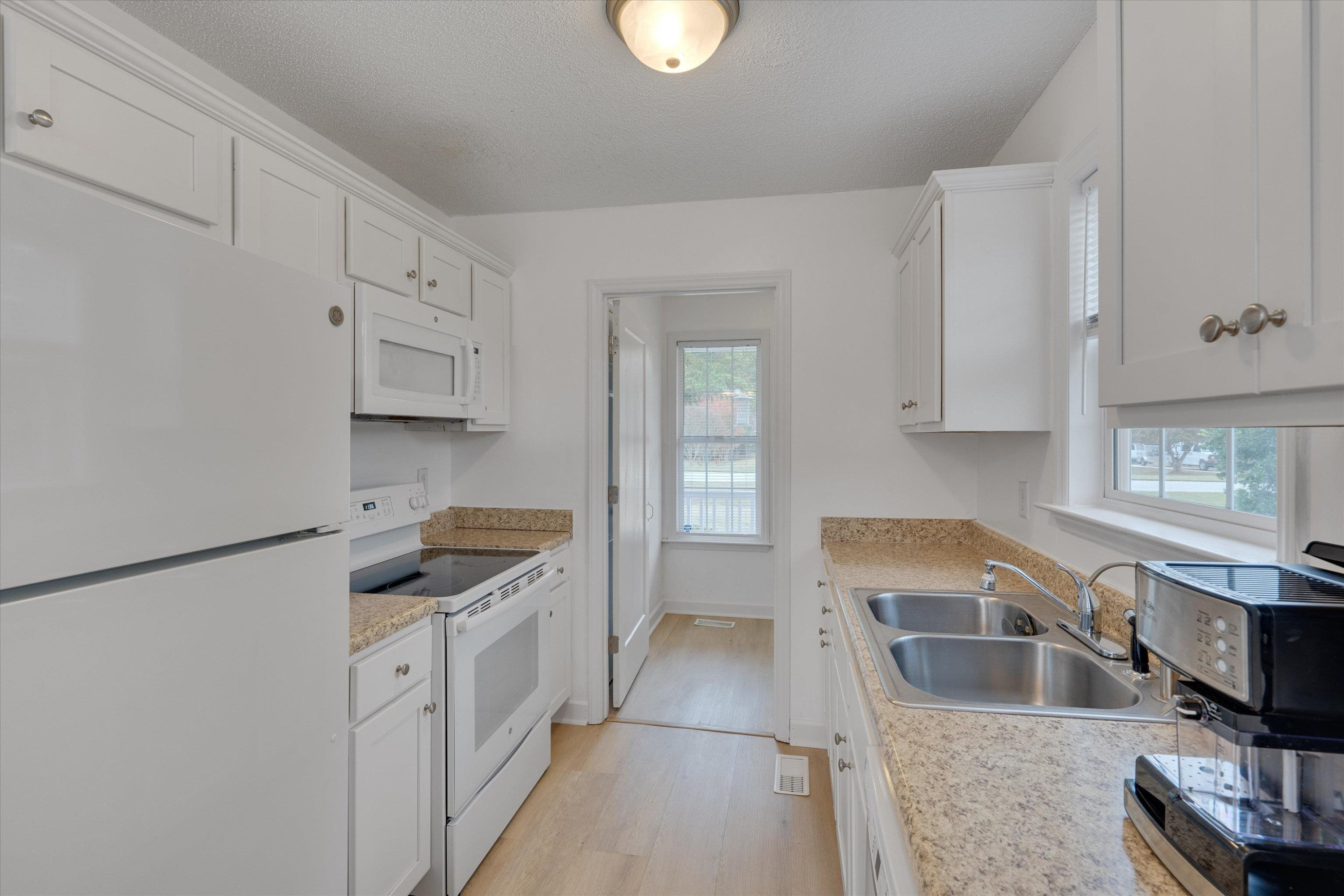 2568 Matthews Road Clayton, NC 27520 - Photo 21 of 26 a kitchen with granite countertop a sink a stove and cabinets