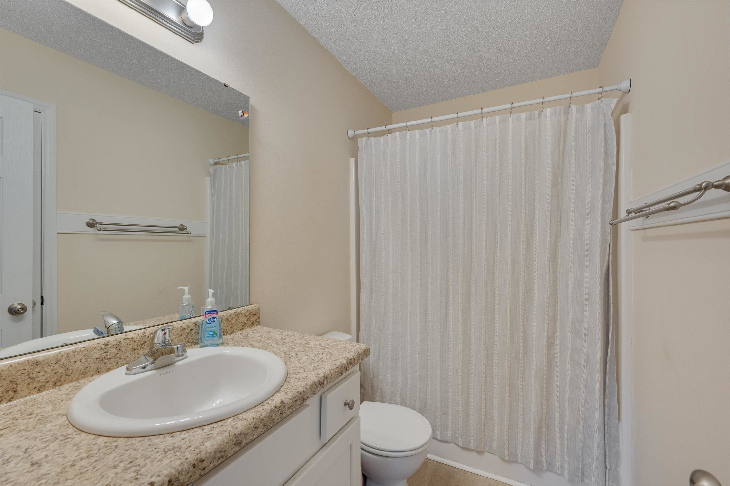 2568 Matthews Road Clayton, NC 27520 - Photo 23 of 26 a bathroom with a granite countertop sink toilet and a mirror