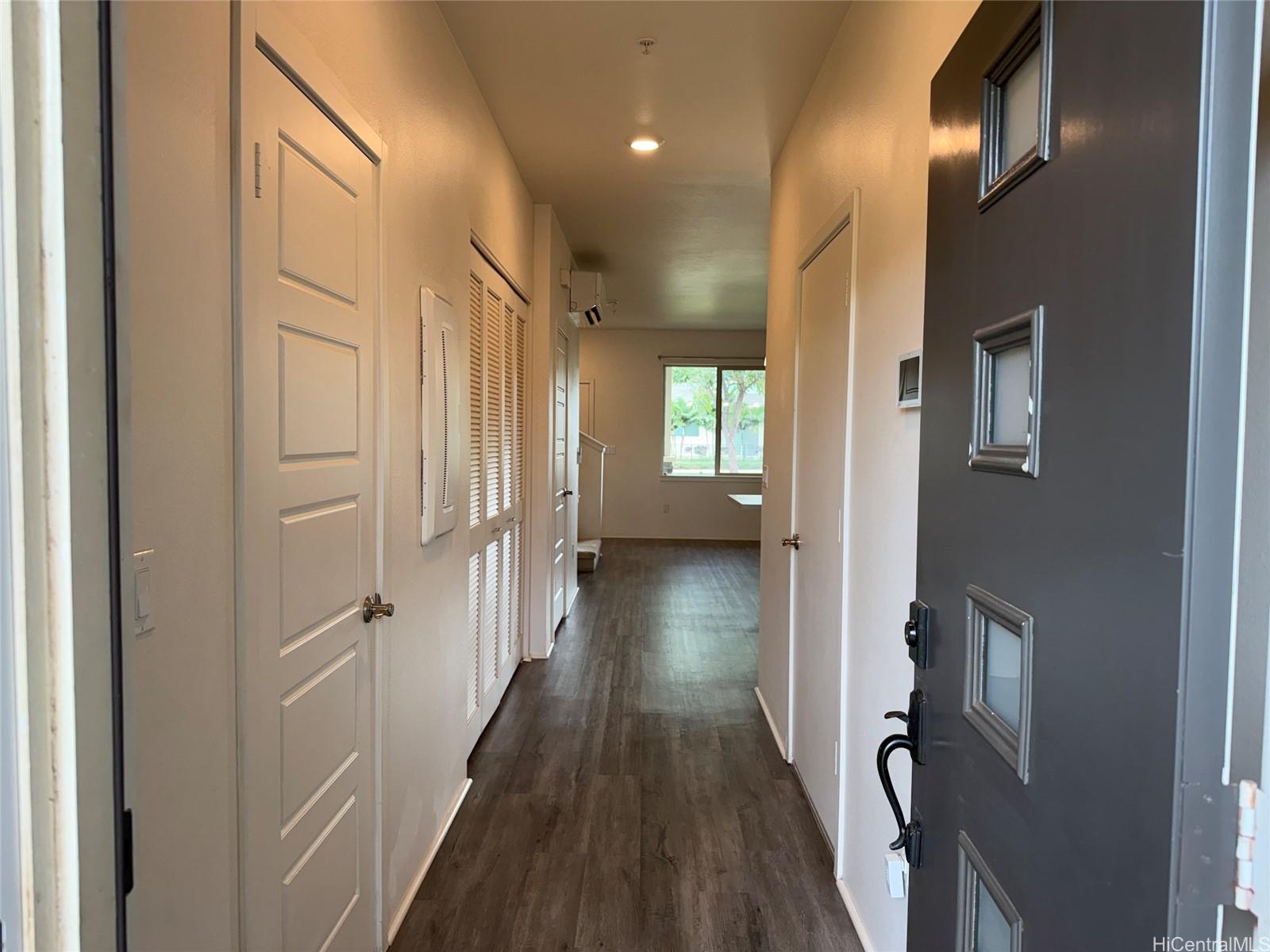 91-3524 Iwikuamo'o Street, Unit 102 Ewa Beach, HI 96706 - Photo 4 of 25 a view of a hallway with wooden floor and staircase