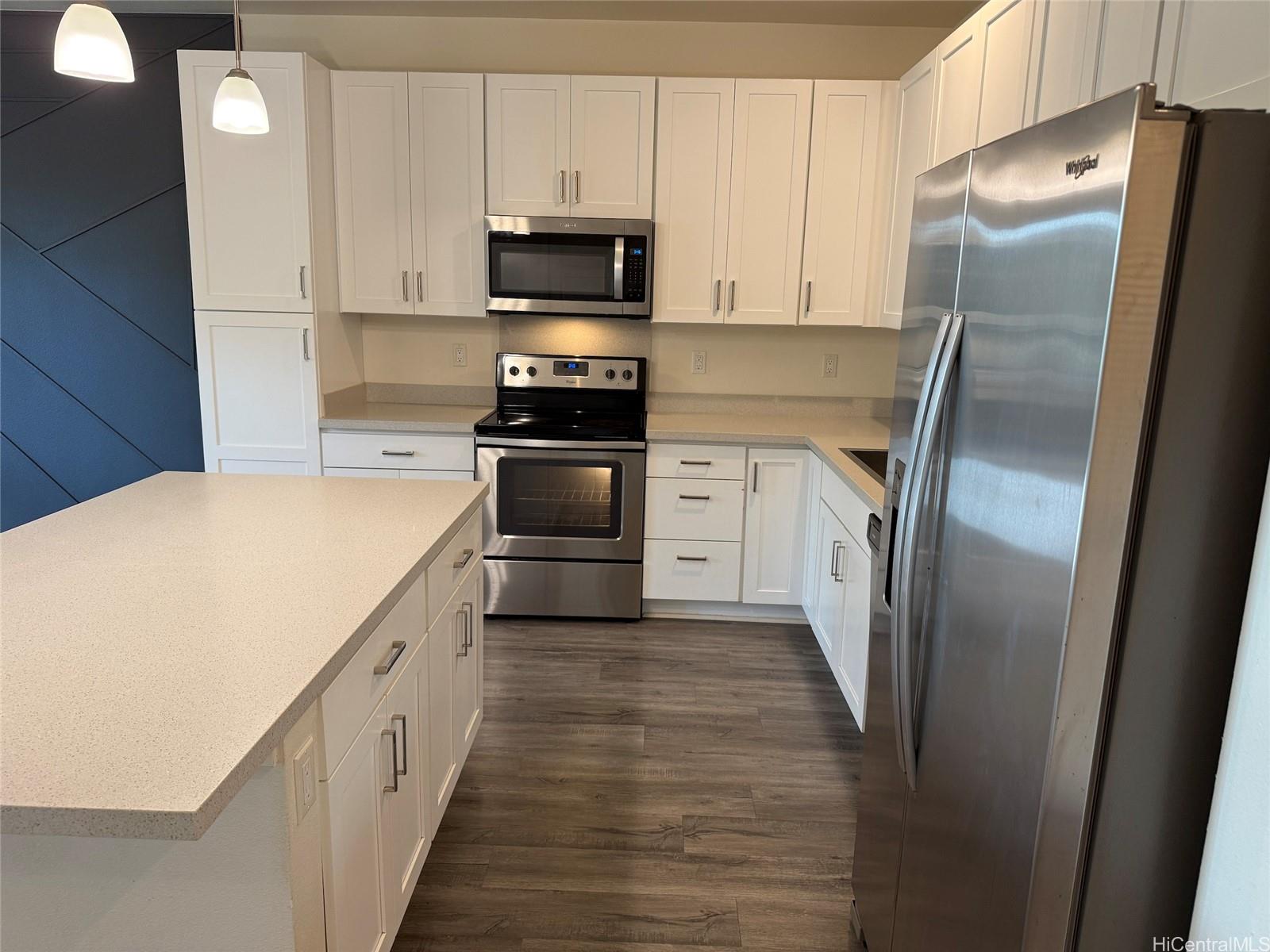 91-3524 Iwikuamo'o Street, Unit 102 Ewa Beach, HI 96706 - Photo 7 of 25 a kitchen with stainless steel appliances a refrigerator stove and sink