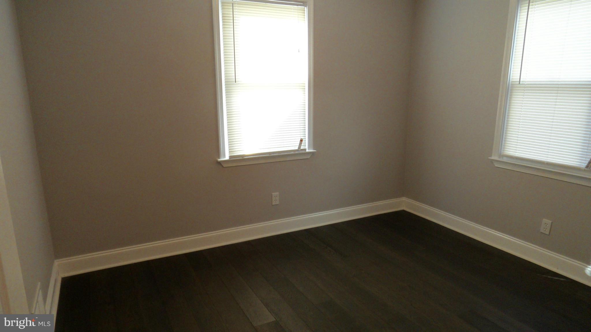 3832 Byfield Road Baltimore, MD 21207 - Photo 11 of 30 an empty room with wooden floor and windows