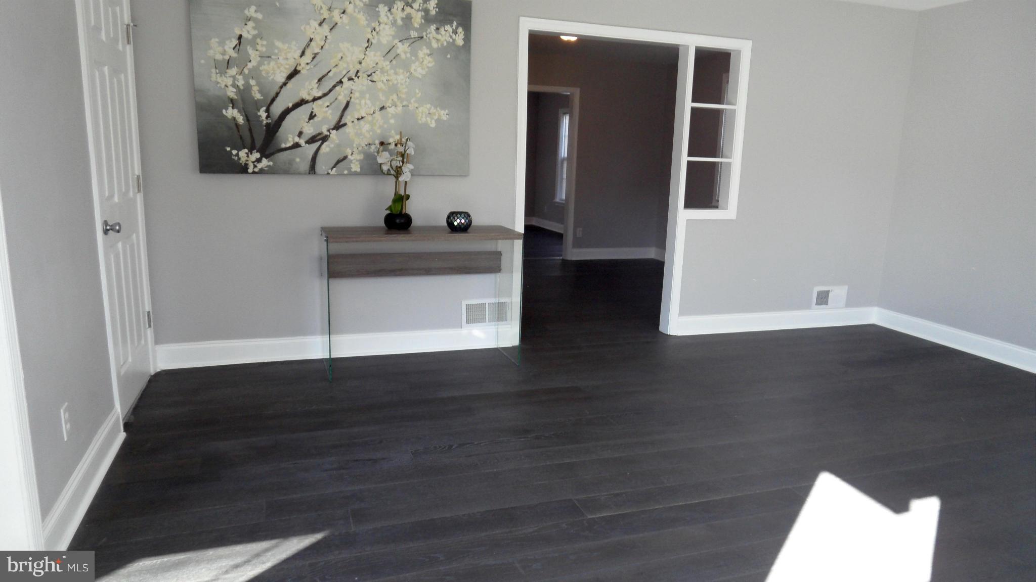 3832 Byfield Road Baltimore, MD 21207 - Photo 3 of 30 an empty room with wooden floor and windows