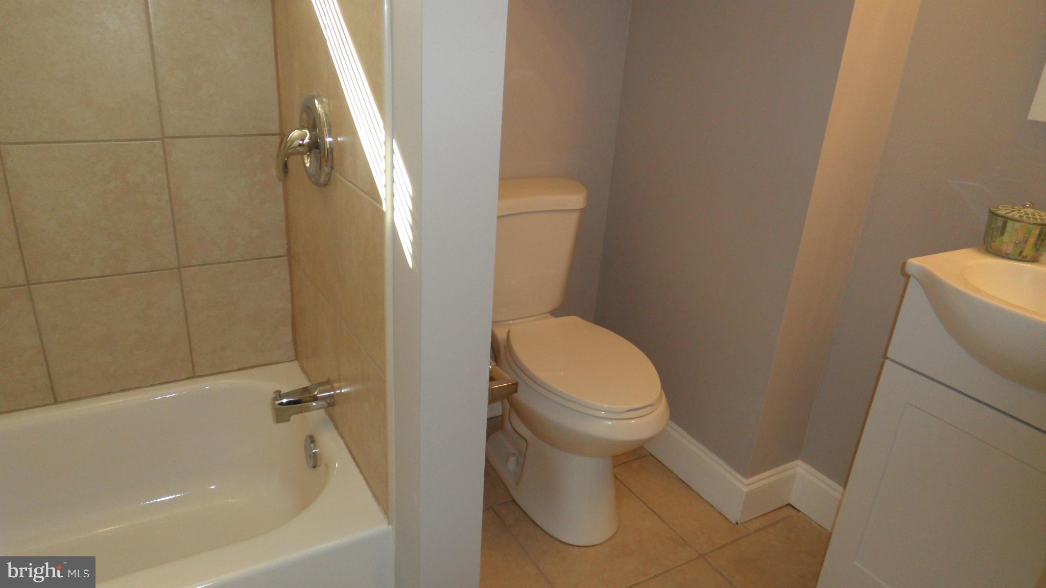 3832 Byfield Road Baltimore, MD 21207 - Photo 26 of 30 a white toilet sitting next to a bath tub