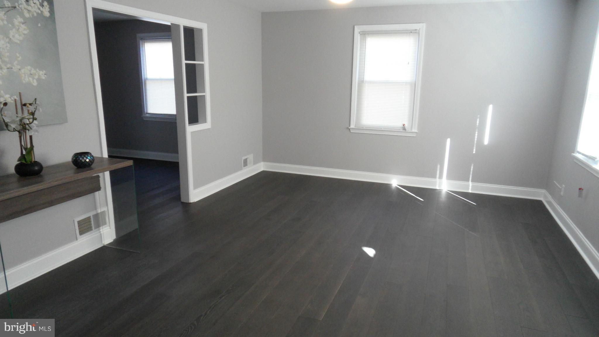 3832 Byfield Road Baltimore, MD 21207 - Photo 4 of 30 an empty room with wooden floor and windows
