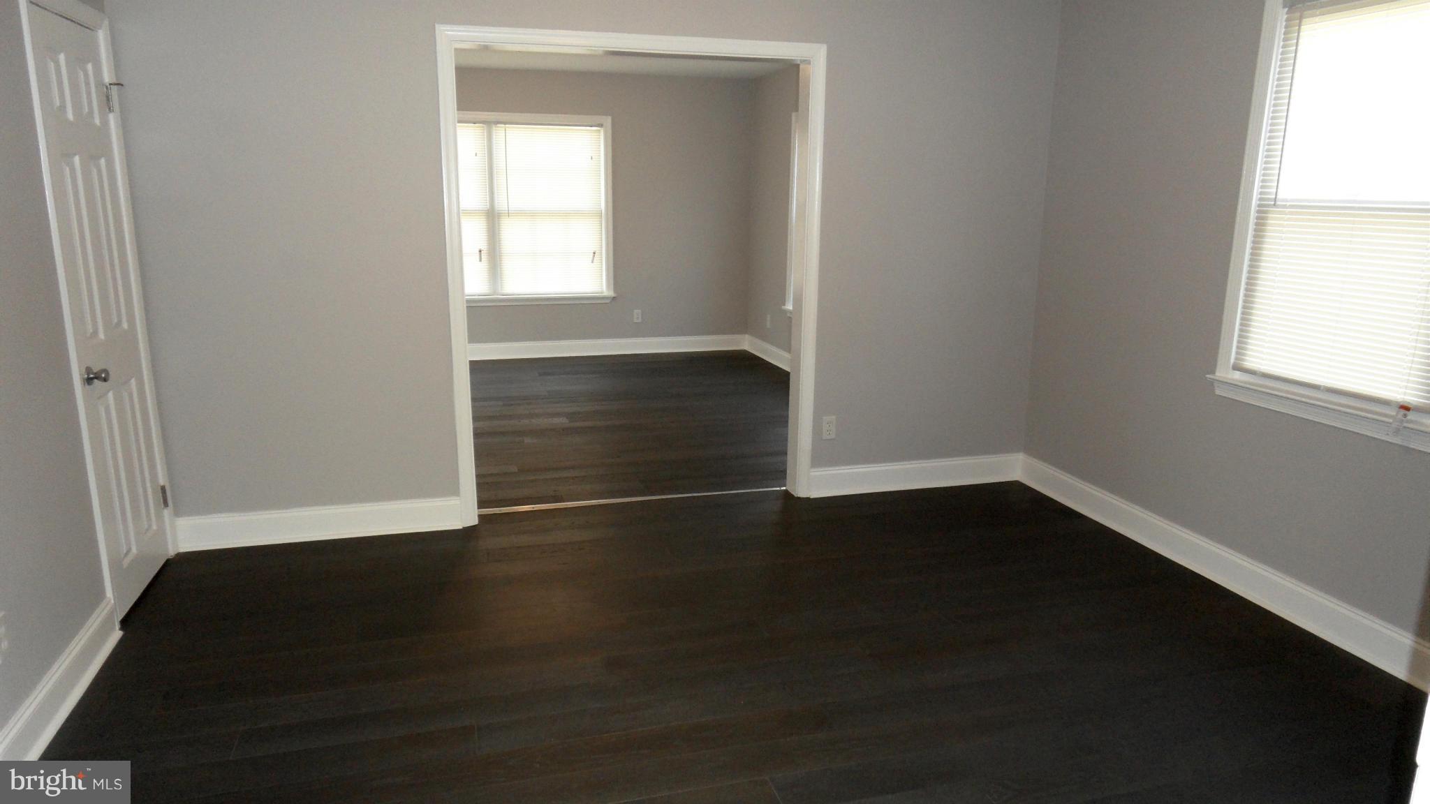 3832 Byfield Road Baltimore, MD 21207 - Photo 5 of 30 an empty room with wooden floor and windows
