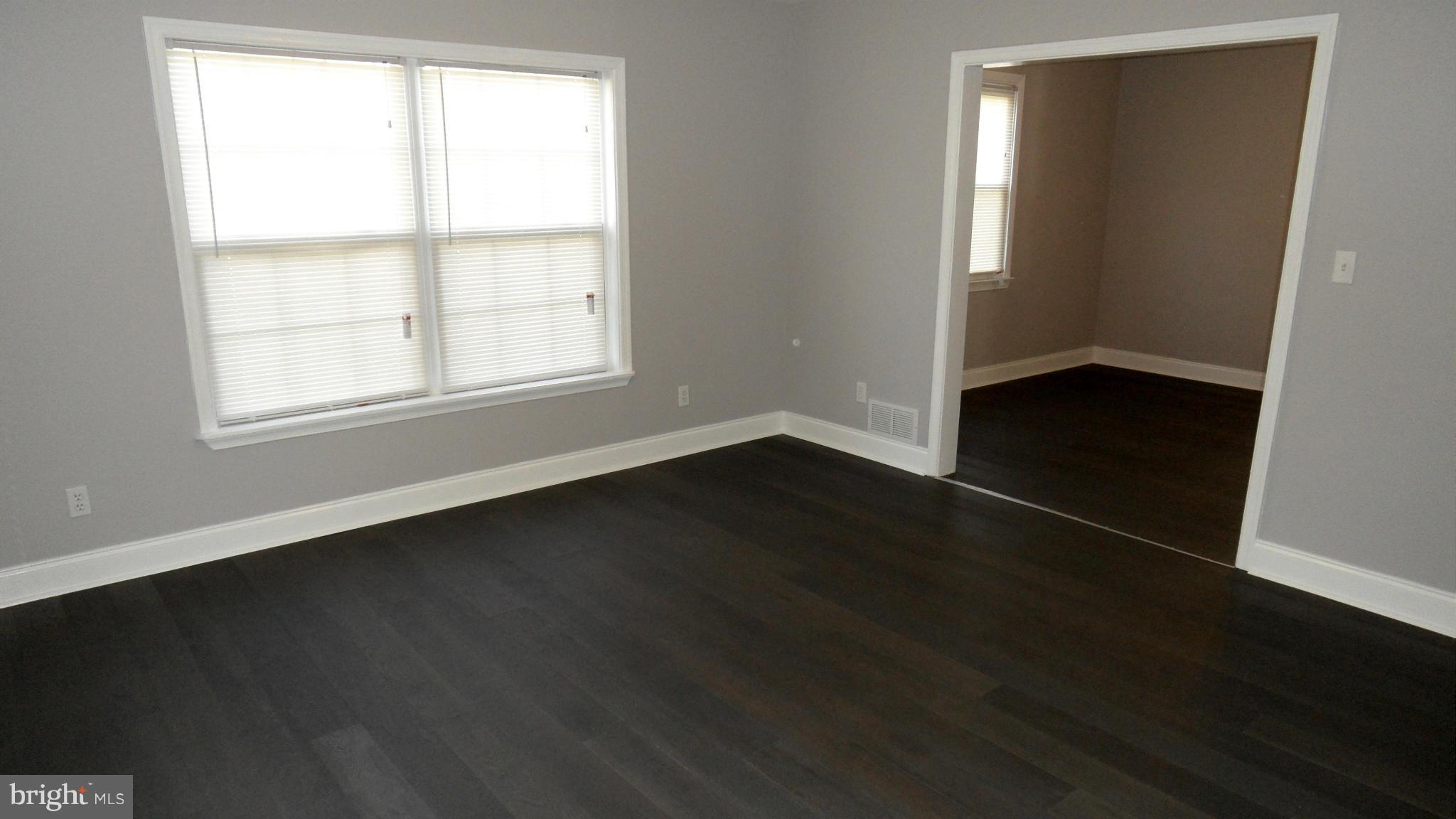 3832 Byfield Road Baltimore, MD 21207 - Photo 7 of 30 an empty room with wooden floor and windows