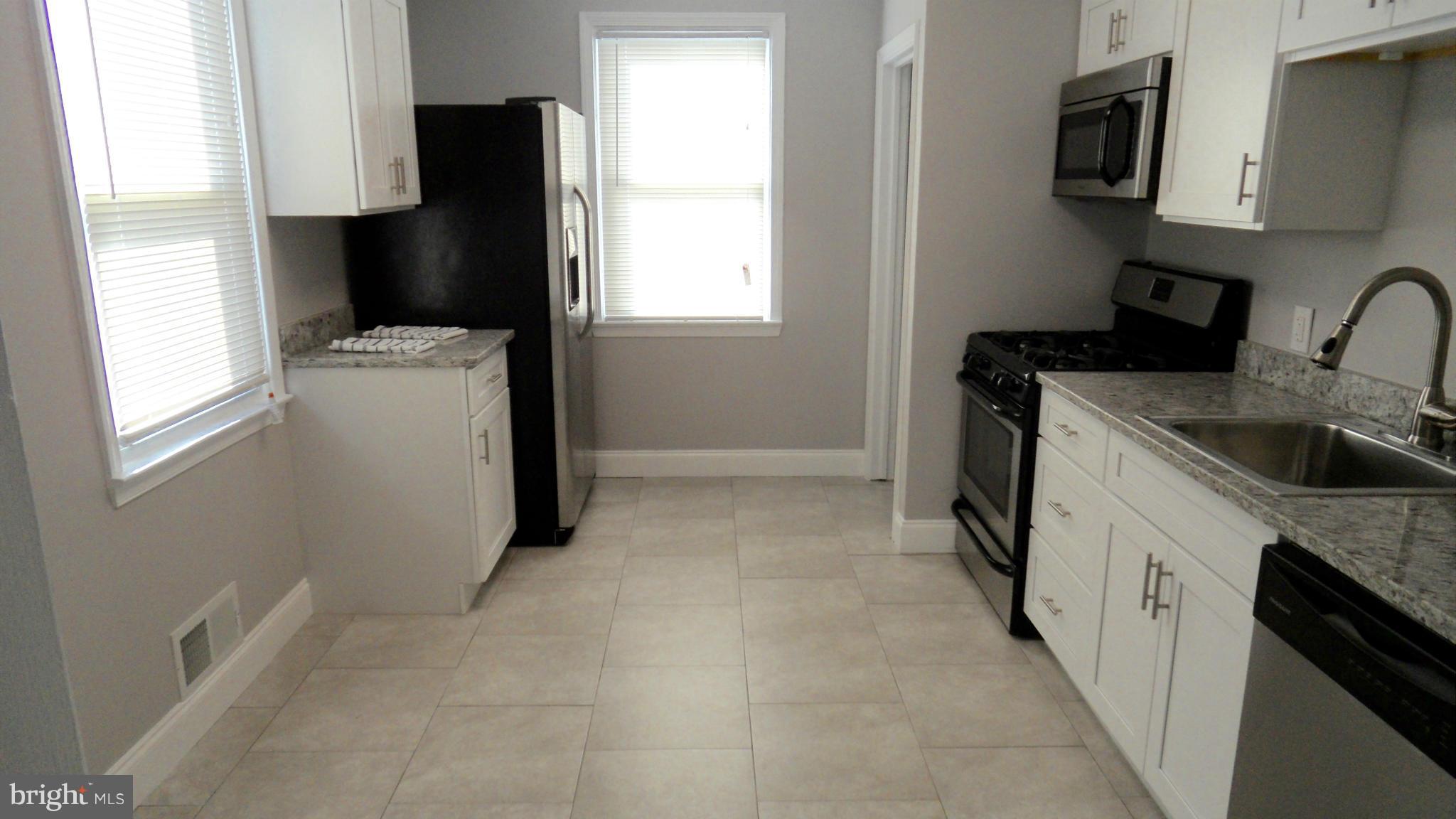 3832 Byfield Road Baltimore, MD 21207 - Photo 8 of 30 a kitchen with a refrigerator and a sink