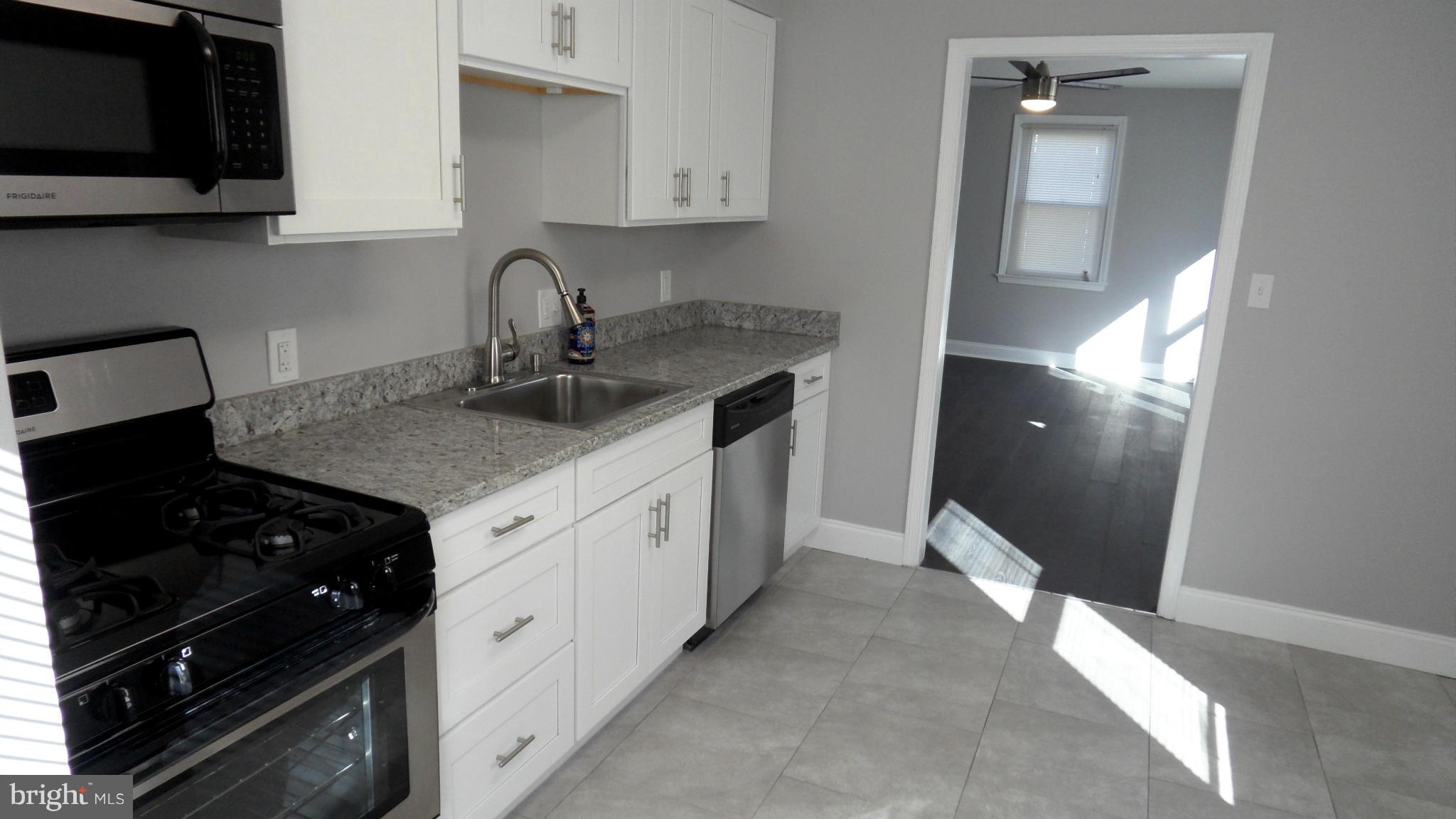 3832 Byfield Road Baltimore, MD 21207 - Photo 10 of 30 a kitchen with stainless steel appliances granite countertop a sink stove and cabinets