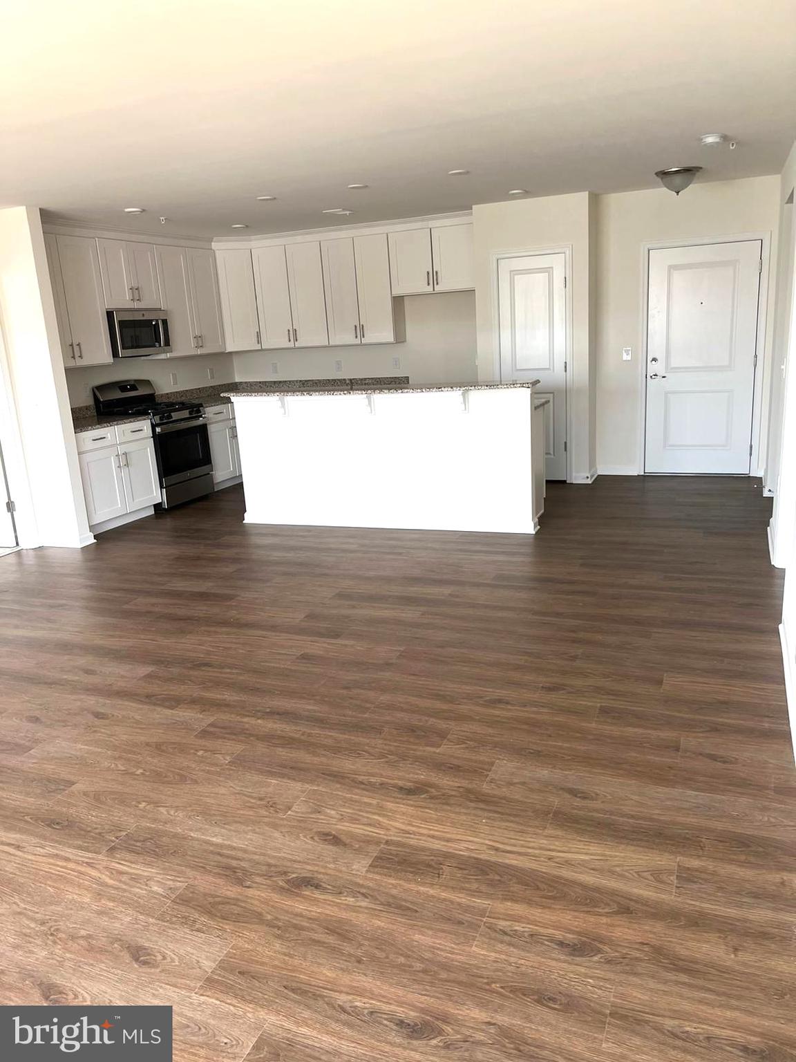 20141 Riesling Lane, Unit 309 Lewes, DE 19958 - Photo 2 of 12 a kitchen with granite countertop a stove a sink and a refrigerator