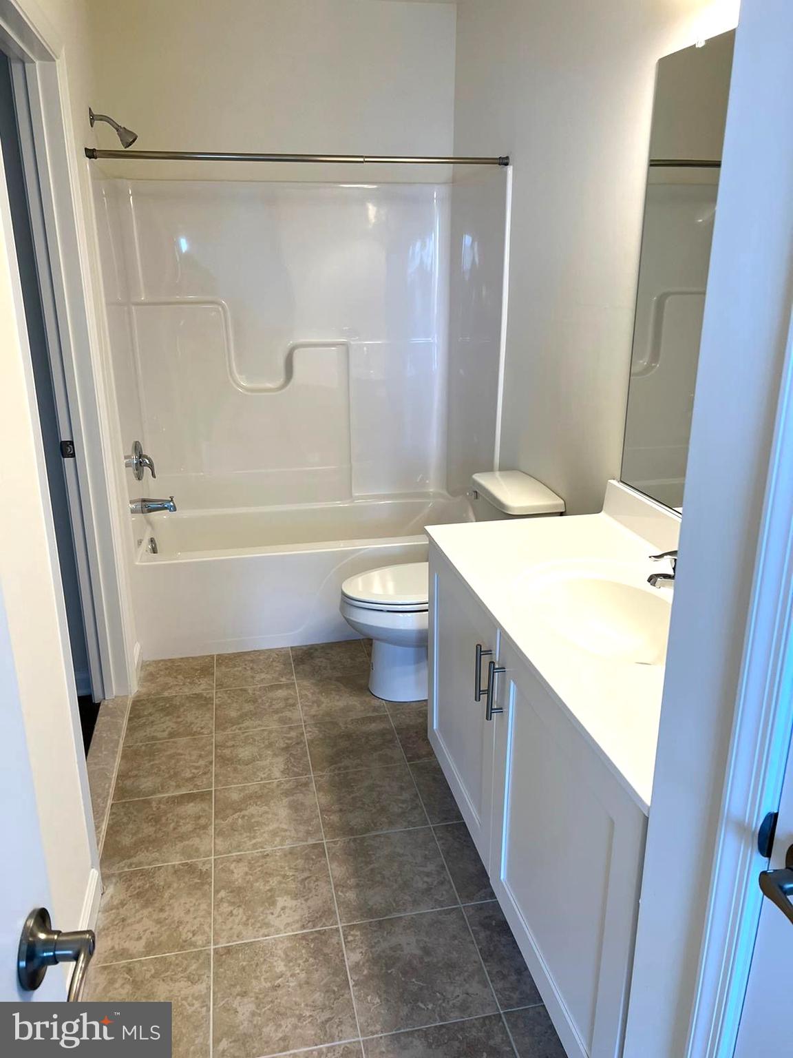 20141 Riesling Lane, Unit 309 Lewes, DE 19958 - Photo 10 of 12 a bathroom with a granite countertop sink toilet a mirror and shower