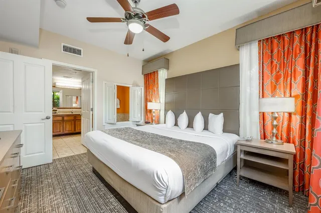 a spacious bedroom with a bed and a chandelier