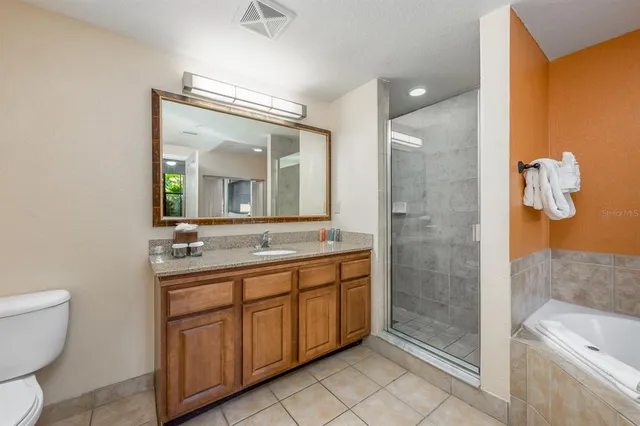 a spacious bathroom with a toilet a sink and mirror