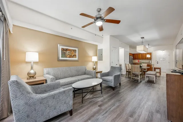 a living room with furniture kitchen view and a window