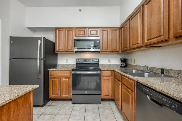 a kitchen with a refrigerator sink and cabinets