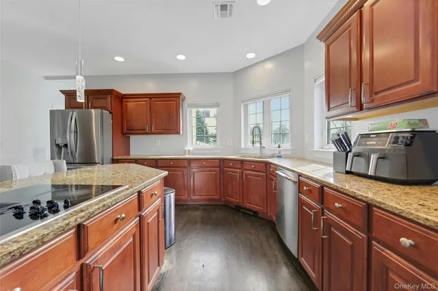 a kitchen with stainless steel appliances granite countertop a sink stove and refrigerator