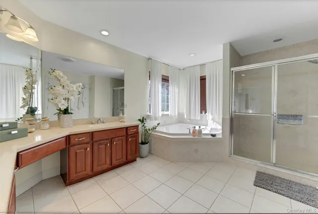 a bathroom with a tub sink shower and mirror