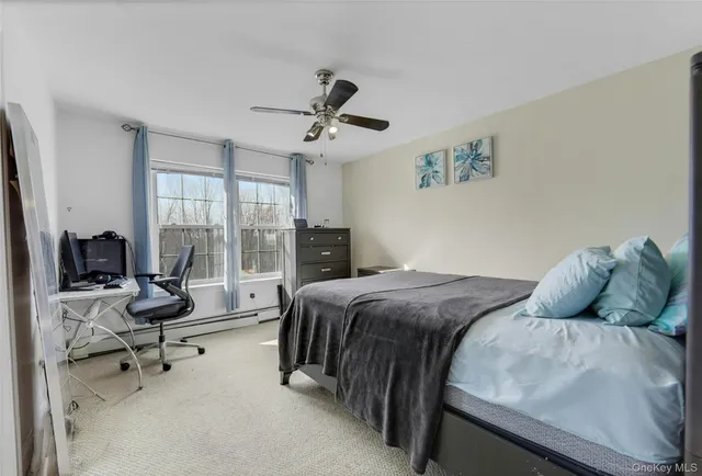 a bedroom with a bed and large windows