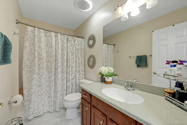 a bathroom with a granite countertop sink toilet mirror and shower