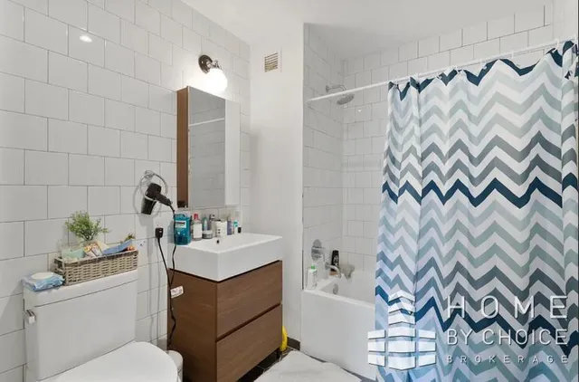 a bathroom with a sink vanity mirror and tub