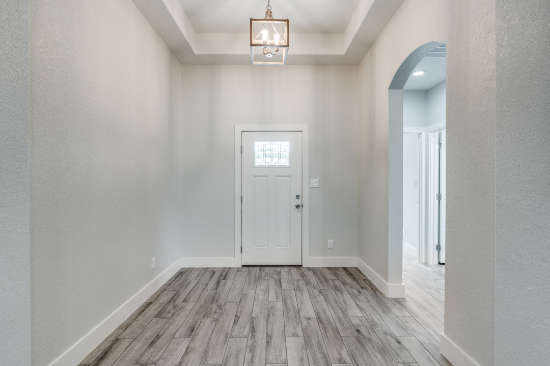 1848 Tanglewood Trail Spring Branch, TX 78070 - Photo 3 of 12 A welcoming entryway features wood-look tile flooring and an elegant tray ceiling with a contemporary light fixture.