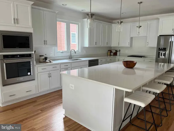 a kitchen with a stove a microwave and wooden floor