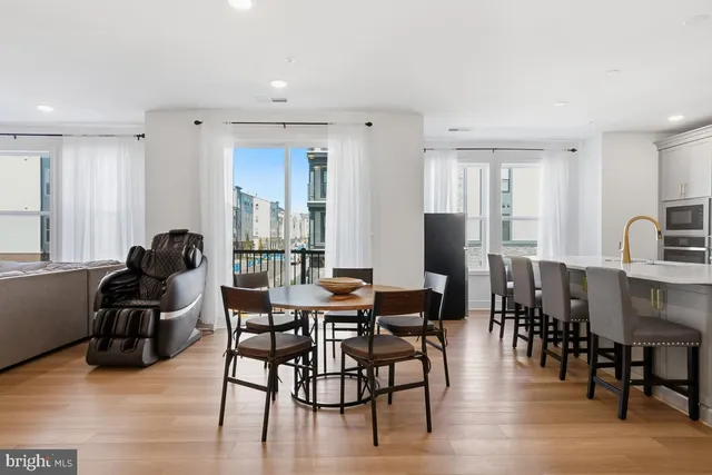 a view of a a dining room with furniture window and wooden floor