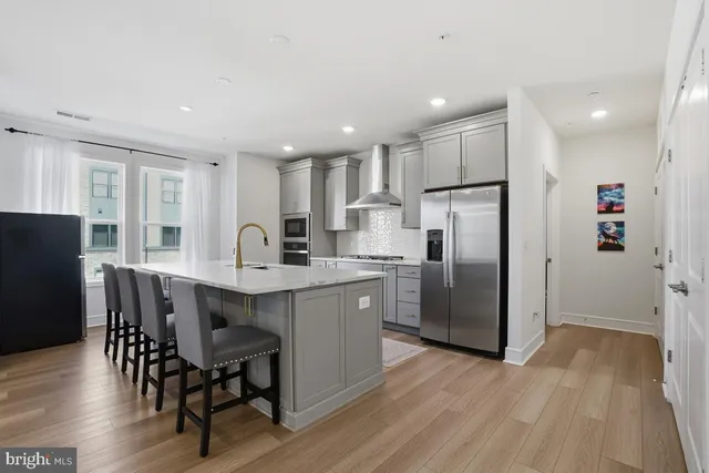 a kitchen with refrigerator a sink and chairs