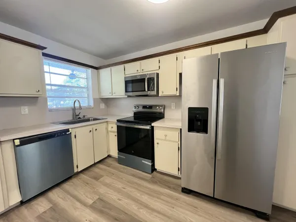 a kitchen with stainless steel appliances a refrigerator sink and microwave