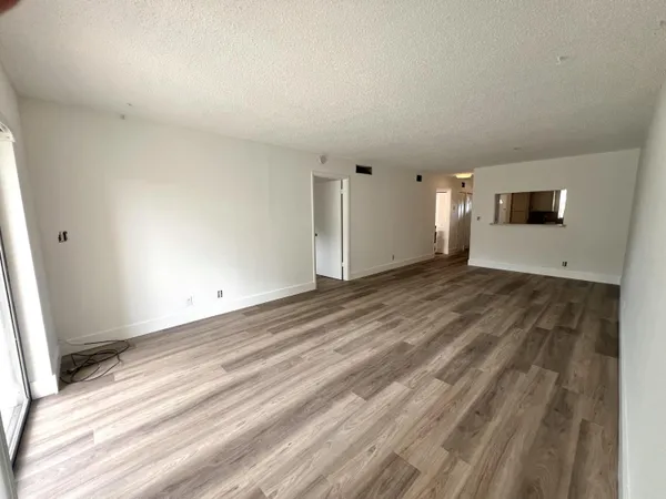 a view of empty room with wooden floor and window