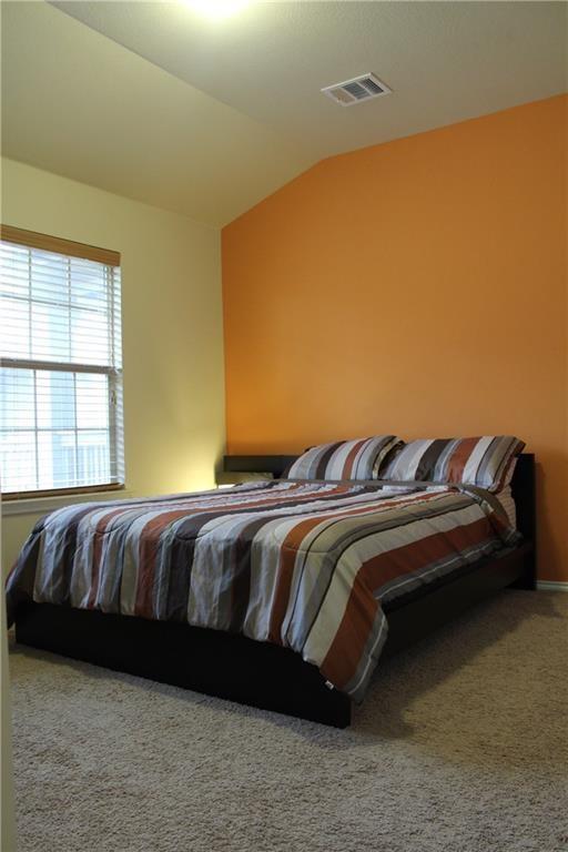 1310 West Parmer Lane, Unit 1503 Austin, TX 78727 - Photo 16 of 26 Bedroom with lofted ceiling and carpet floors