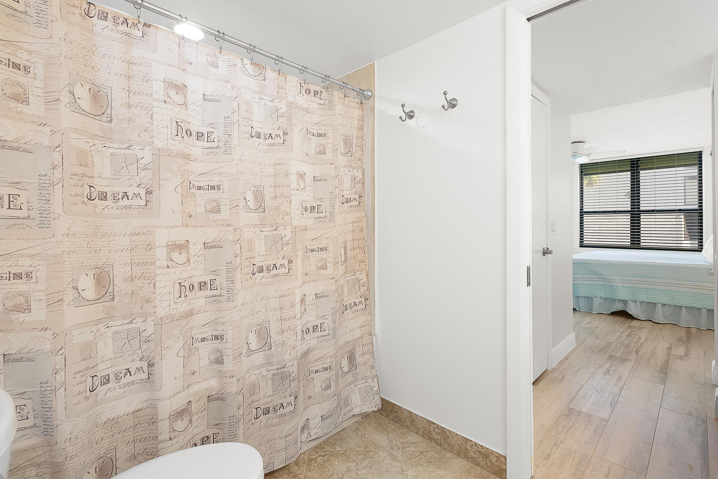 4100 North Hwy A1A, Unit 315 Hutchinson Island, FL 34949 - Photo 22 of 41 a bathroom with a toilet and a shower curtain