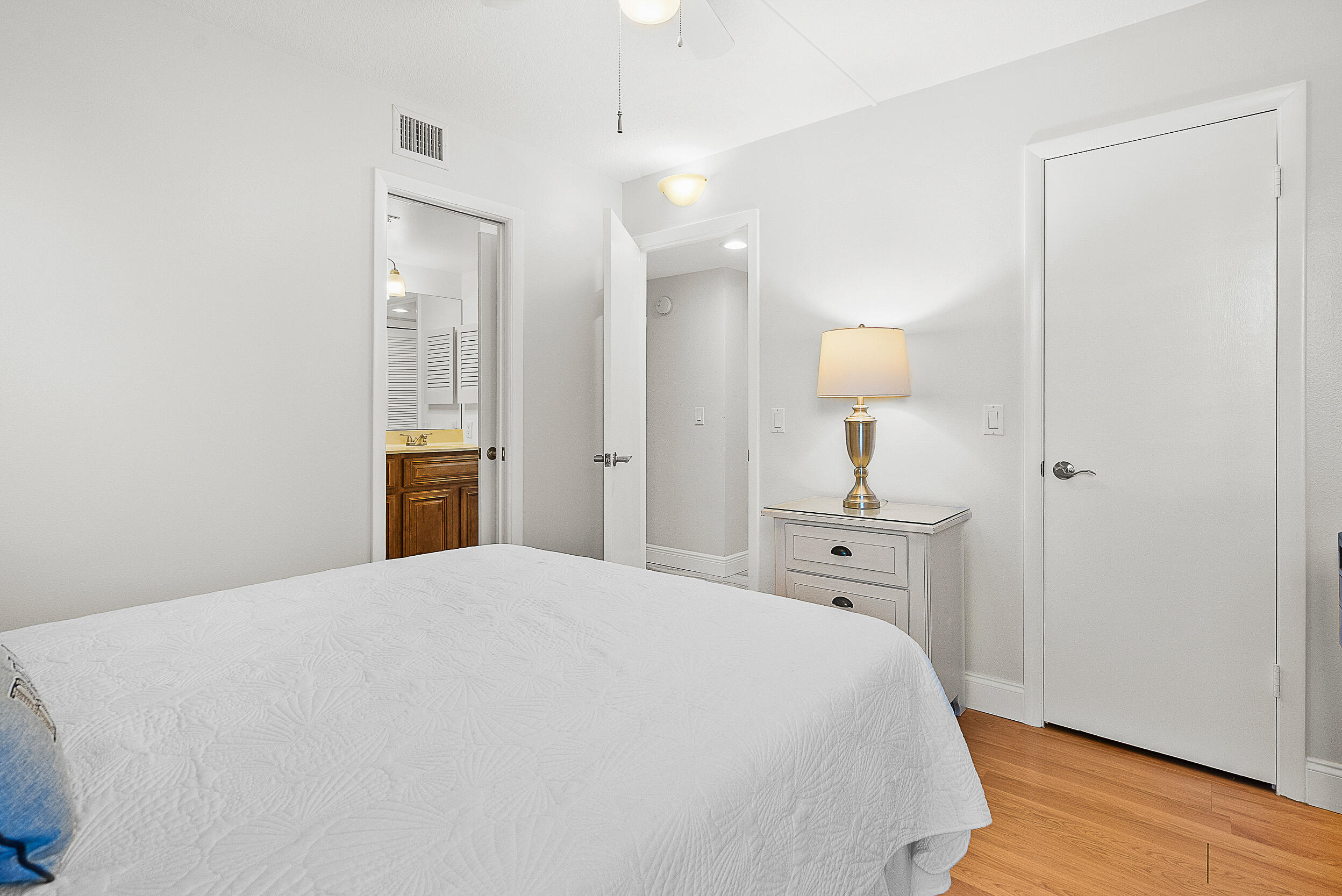 4100 North Hwy A1A, Unit 315 Hutchinson Island, FL 34949 - Photo 26 of 41 a large white bed in a white room with closet and wooden floor