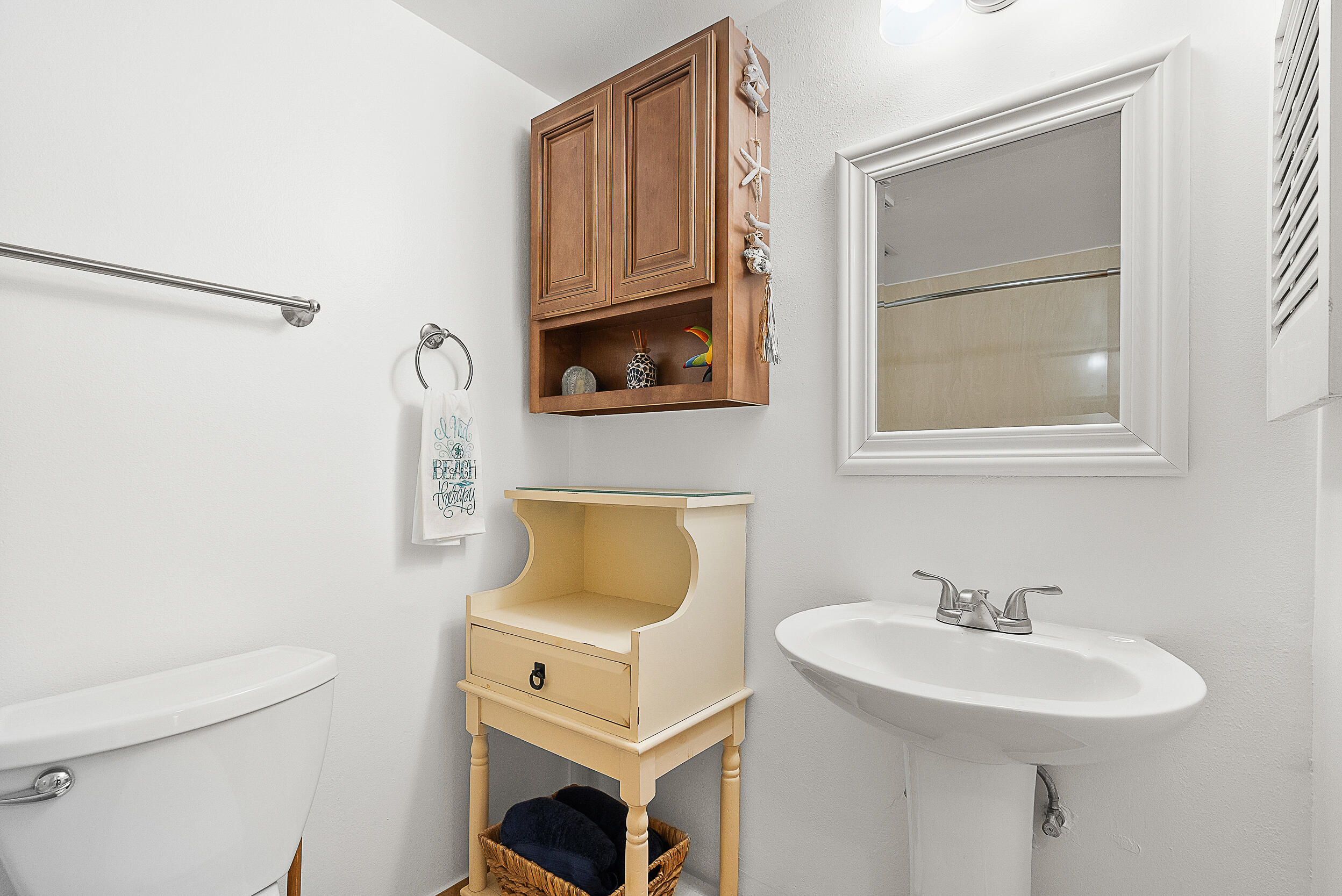 4100 North Hwy A1A, Unit 315 Hutchinson Island, FL 34949 - Photo 29 of 41 a bathroom with a sink a toilet and a mirror