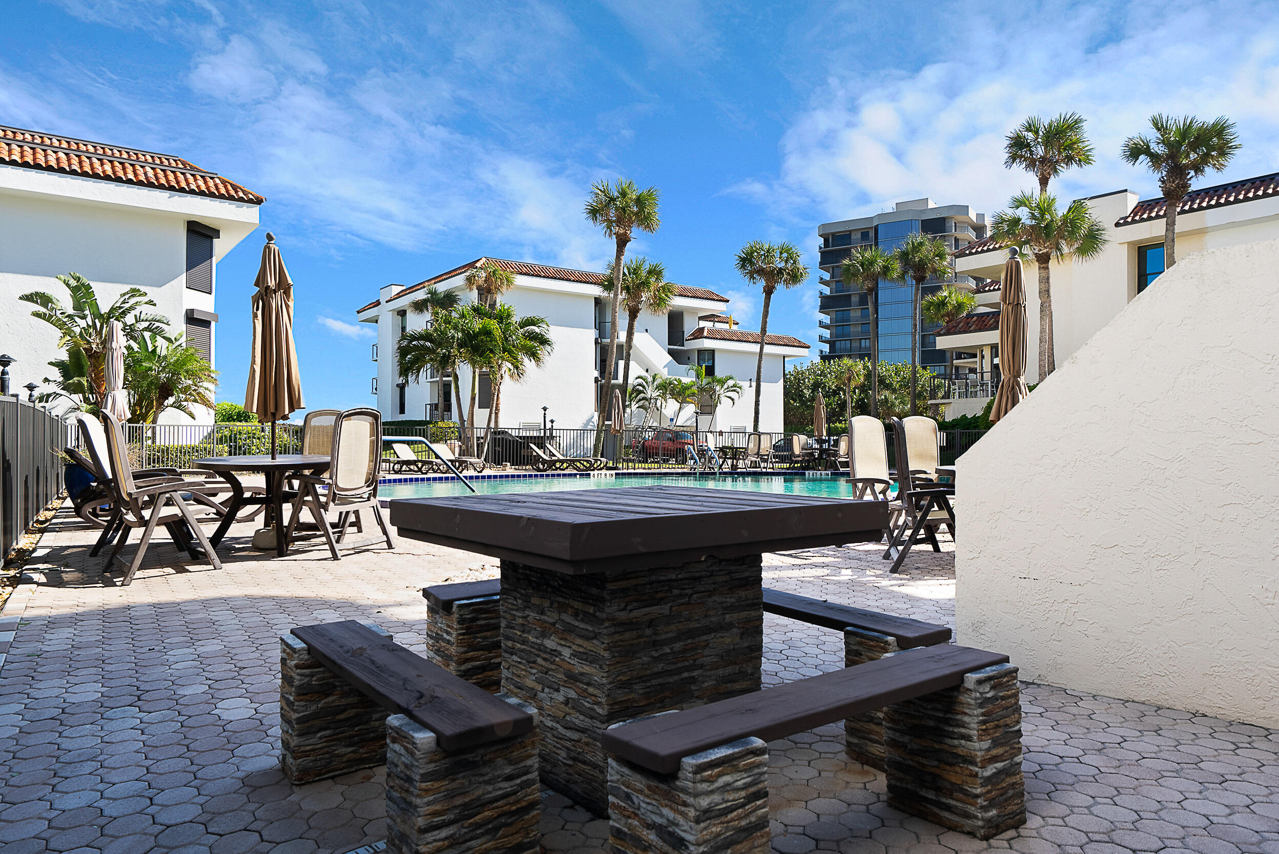 4100 North Hwy A1A, Unit 315 Hutchinson Island, FL 34949 - Photo 37 of 41 a view of a patio with table and chairs potted plants