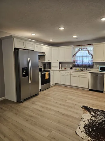 a kitchen with stainless steel appliances granite countertop a refrigerator sink and microwave