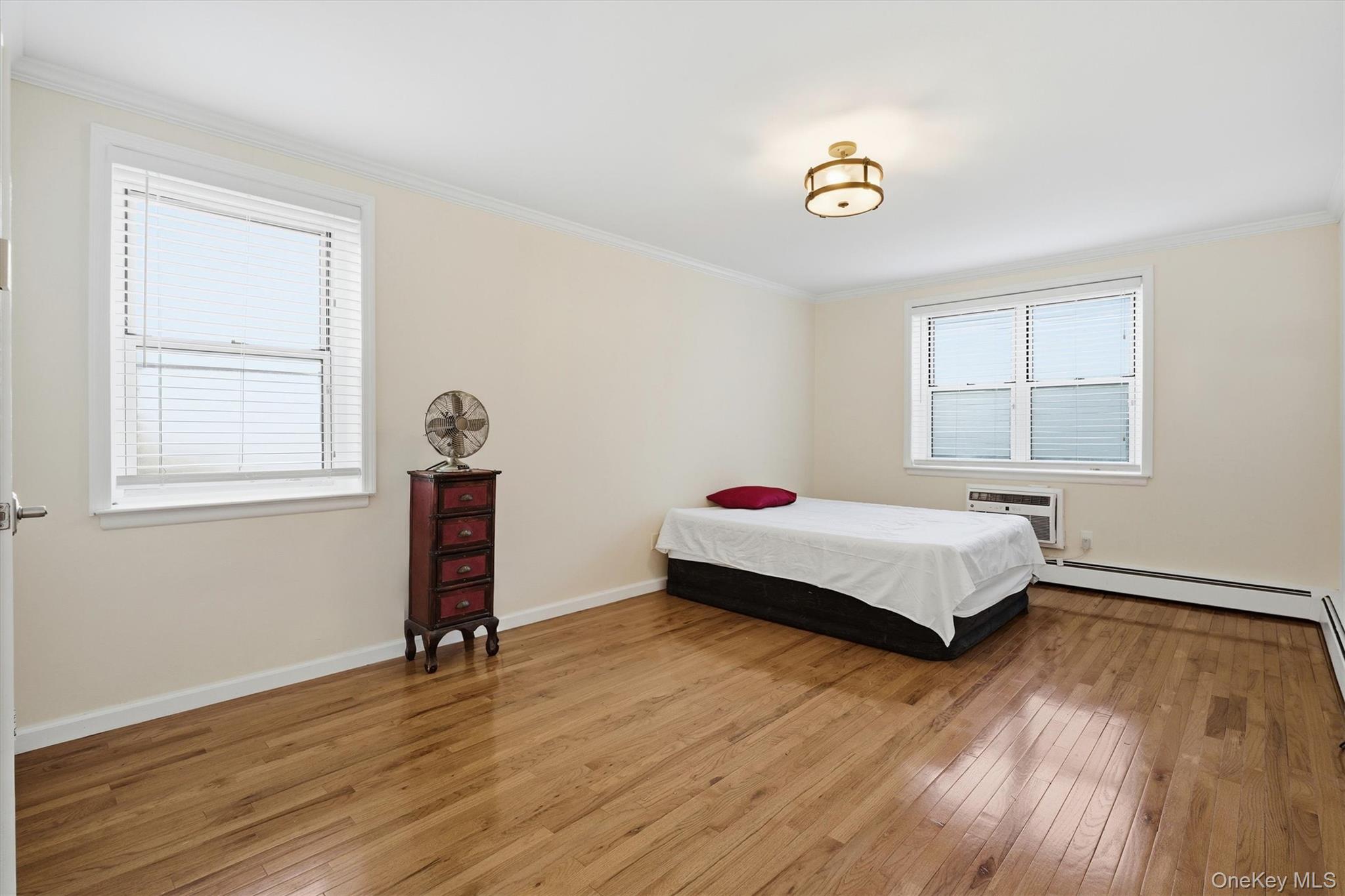 25 Chapel Place, Unit 1B Great Neck, NY 11021 - Photo 13 of 33 a bedroom with a bed and a window