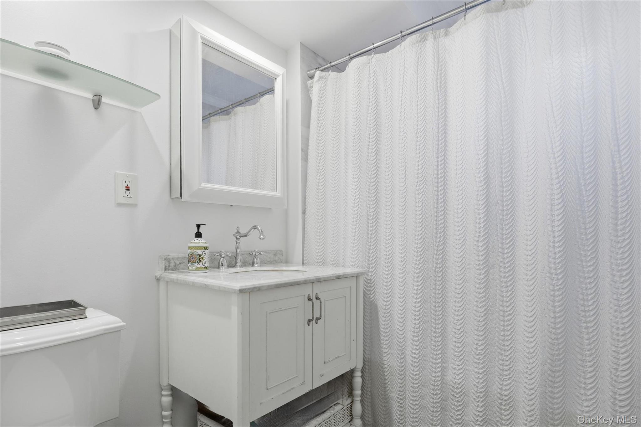 25 Chapel Place, Unit 1B Great Neck, NY 11021 - Photo 19 of 33 a bathroom with a sink a vanity and a mirror