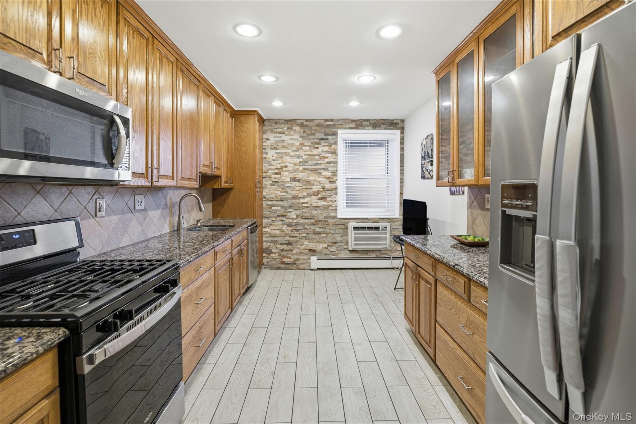 25 Chapel Place, Unit 1B Great Neck, NY 11021 - Photo 7 of 33 a kitchen with stainless steel appliances a sink stove and refrigerator