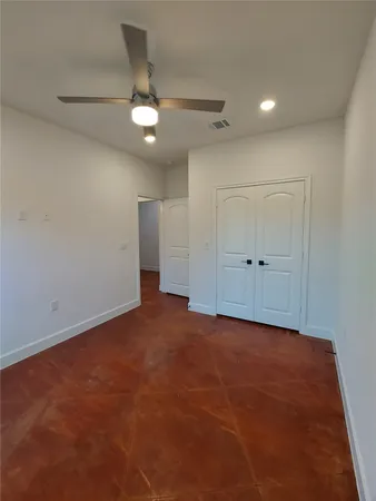 an empty room with an entryway and fan