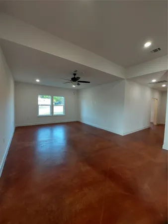 an empty room with wooden floor and windows in it