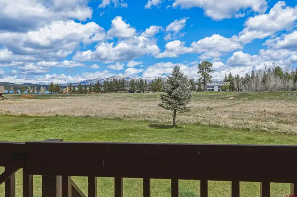 a view of a balcony with wooden floor & fence
