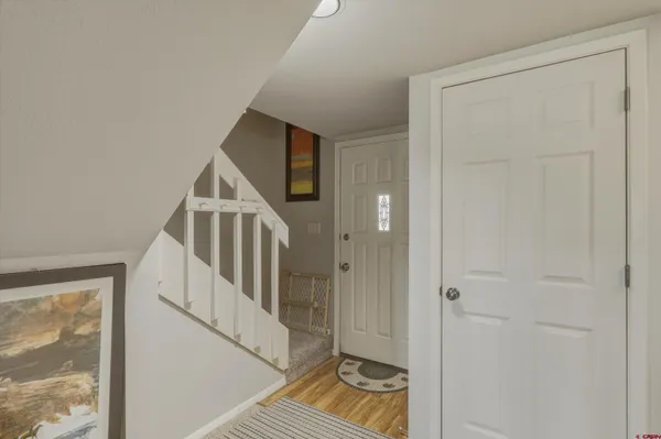 a view of a hallway with wooden floor and entryway