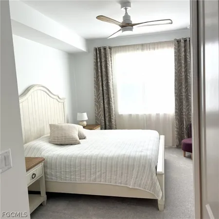 a bedroom with a bed a window and a chandelier