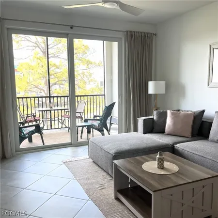 a living room with furniture and a floor to ceiling window