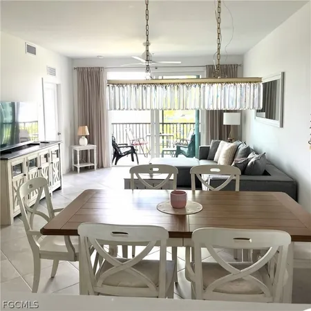 a dining room with furniture a chandelier and wooden floor