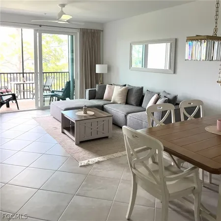 a living room with furniture and a floor to ceiling window